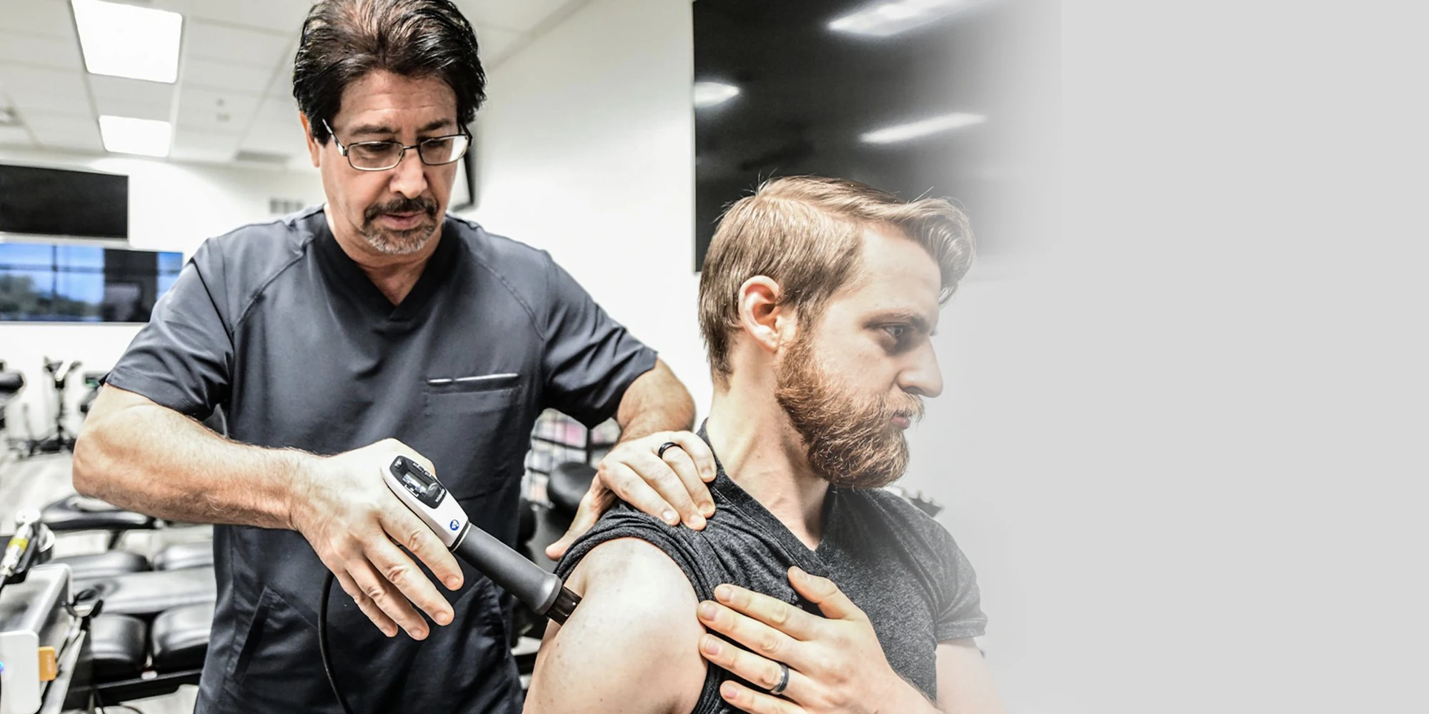 Pain Management Chandler AZ Man Receiving Shockwave Therapy On Shoulder