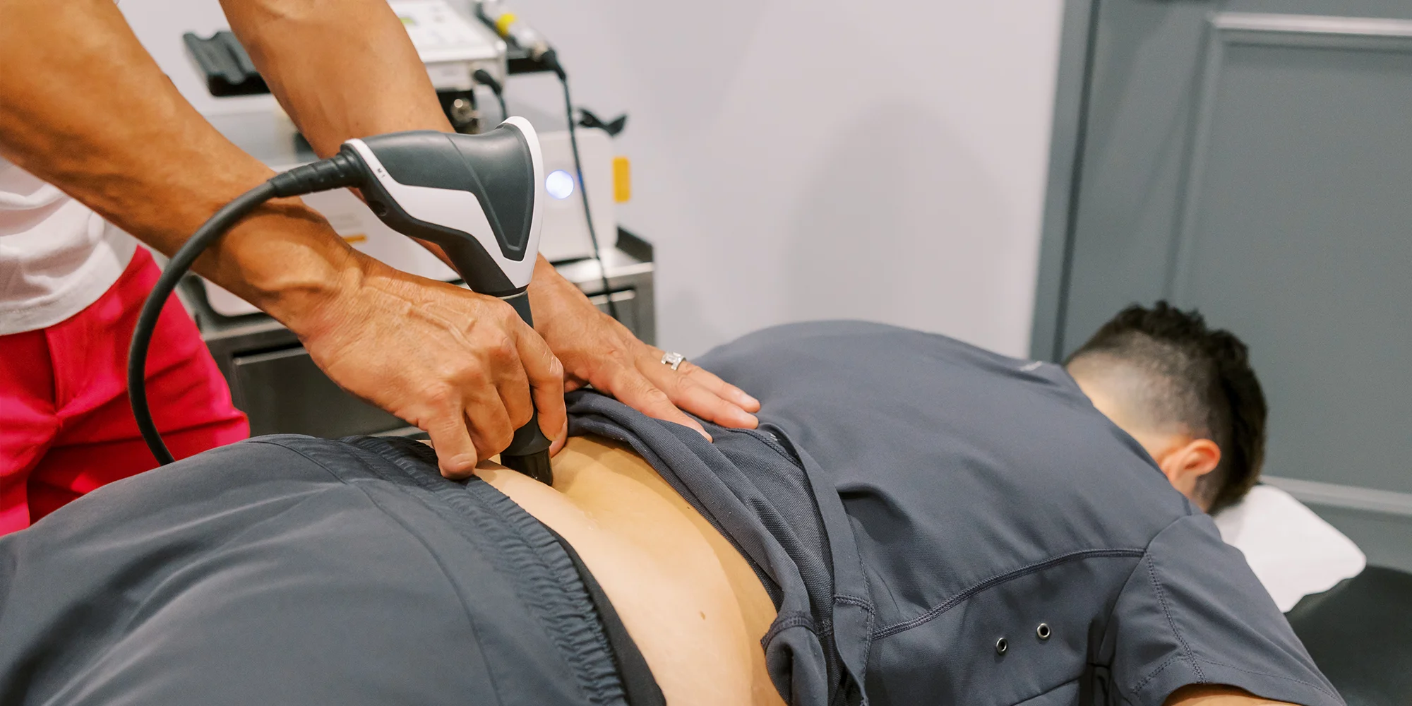 Pain Management Chandler AZ Patient Receiving Shockwave Therapy On Back